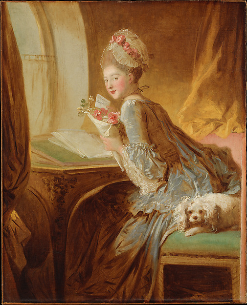 A woman holding flowers and a letter turns from her desk to look towards the viewer.